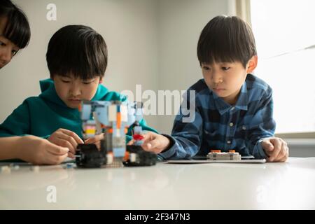 Elementary School Students Assembling Programming Robot Stock Photo