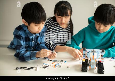 Elementary School Students Assembling Programming Robot Stock Photo
