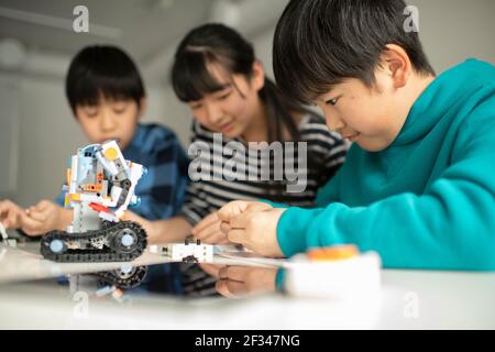 Elementary School Students Assembling Programming Robot Stock Photo