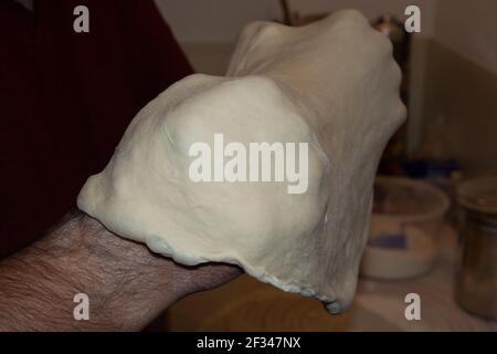 man hands throw rolled pizza dough into the air side view the ending of the dynamics Stock Photo