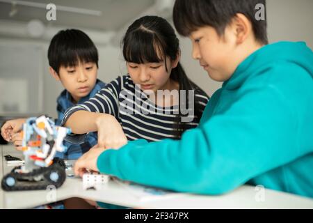 Elementary School Students Assembling Programming Robot Stock Photo