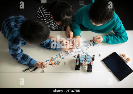 Elementary School Students Assembling Programming Robot Stock Photo