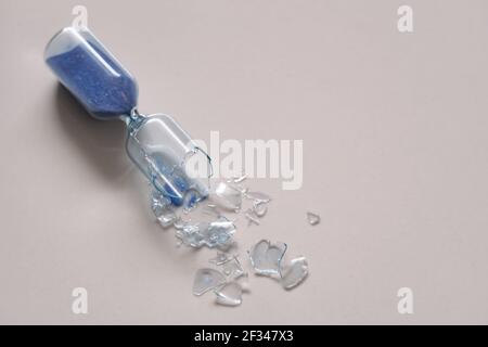 broken hourglass with blue sand Stock Photo