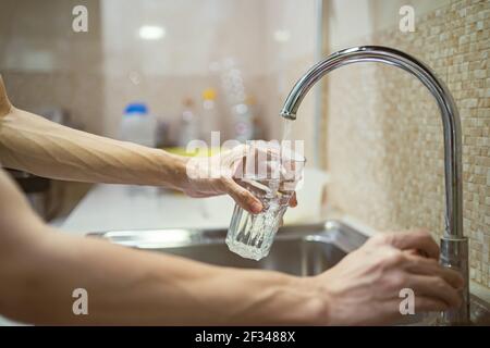 Fill a drinking glass with tap water Stock Photo