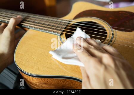 Cleaning acoustic guitar with microfiber cloth Stock Photo