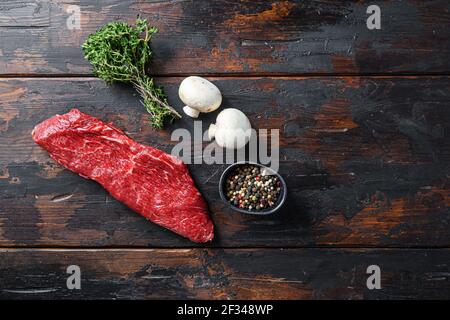 Whole tri tip steak with fresh seasoningsm thyme, organic tri-tip roast with fat marbled through the meat ready to roast or barbecue on rustic wooden Stock Photo