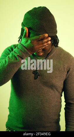 Hands covering eyes of a young black man Stock Photo - Alamy