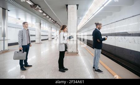 various subway passengers waiting for the arrival of the train . Stock Photo