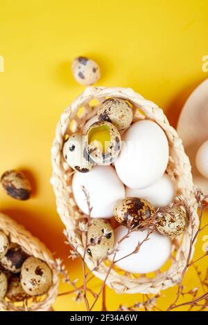 Easter eggs are minimalistically, decorated with dry flowers on yellow background. Top view,  Copy space, Creative  flat lay holiday composition. Stock Photo