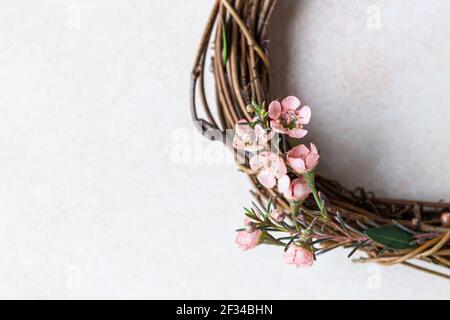 Detail of a decorative spring wreath made of twigs and flowers. DIY creativity. Close up. Selective focus. Stock Photo