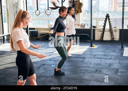 Excited young ladies staying in shape and using skipping ropes Stock Photo