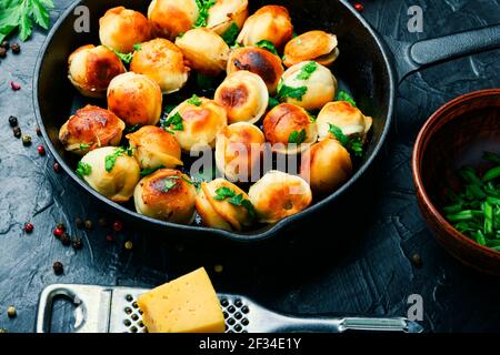 Frying pan with roasted tasty pelmeni.Fried dumplings Stock Photo