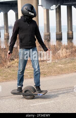 A young man on a ONEWHEEL a self balancing single wheel electric