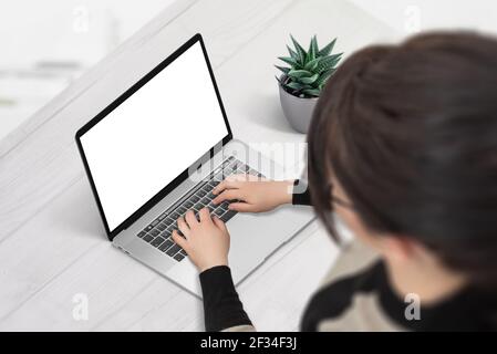 Woman work on laptop computer with isolated screen for mockup, app or web site presentation. Isometric position, over shoulder view Stock Photo