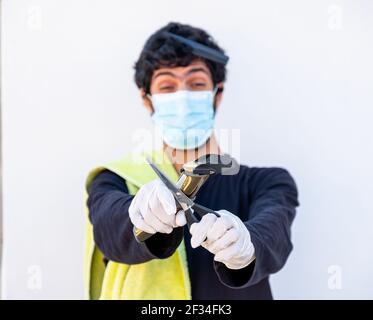 Arabic Muslim guy wearing mask and holding barber equipment Stock Photo