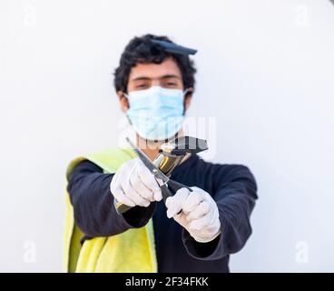 Arabic Muslim guy wearing mask and holding barber equipment Stock Photo