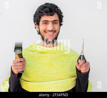 Arabic msulim mna feeling happy while holding bareber tools Stock Photo