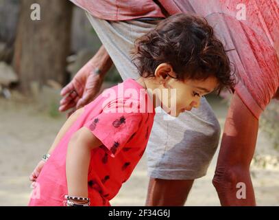 An Indian-origin little boy with grandfather looking towards the ground, india.concept for Childhood joys, childhood memories, baby's face expressions Stock Photo