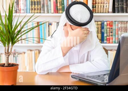 Arabic muslim man feeling bored at his home office Stock Photo