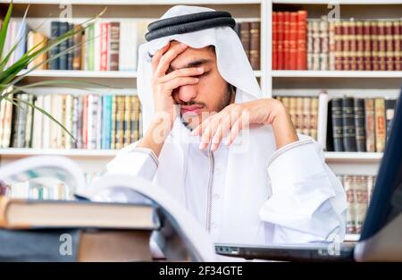 Arabic Muslim man feeling upset while studying online Stock Photo