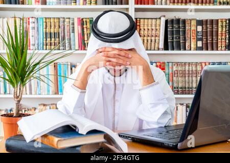 Arabic Muslim man feeling upset while studying online Stock Photo