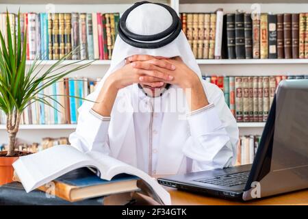 Arabic Muslim man feeling upset while studying online Stock Photo