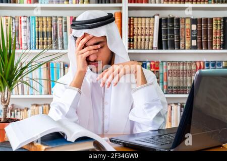 Arabic Muslim man feeling upset while studying online Stock Photo