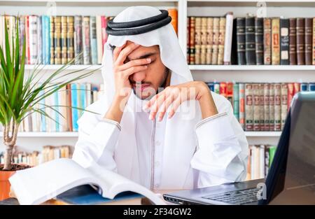 Arabic Muslim man feeling upset while studying online Stock Photo