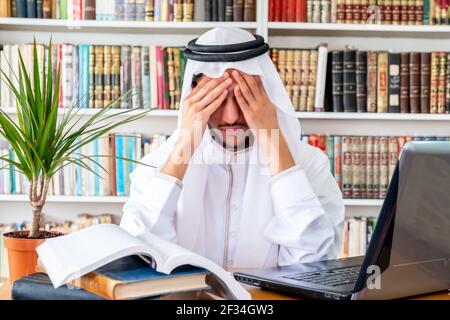 Arabic Muslim man feeling upset while studying online Stock Photo