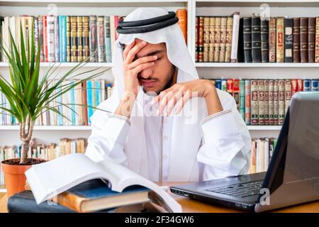 Arabic Muslim man feeling upset while studying online Stock Photo