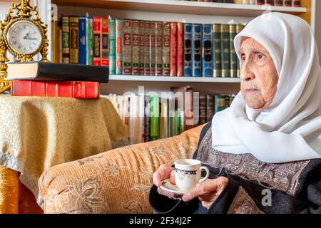 Arabic Muslim old woman drinking coffee Stock Photo