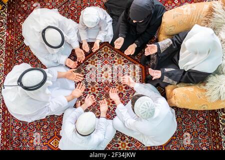 Happy Arabic family praying for god during Ramadan Stock Photo