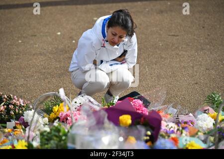 A woman looks at floral tributes left at the band stand in Clapham Common, London, for murdered Sarah Everard. Serving police constable Wayne Couzens, 48, appeared in court on Saturday charged with kidnapping and murdering the 33-year-old marketing executive, who went missing while walking home from a friend's flat in south London on March 3. Picture date: Monday March 15, 2021.