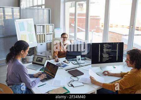 High angle view at diverse software development team using computers and writing code while collaborating on project in modern office, copy space Stock Photo