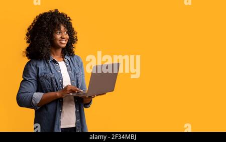 Happy african american young woman with laptop Stock Photo
