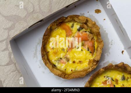Mini baked salmon quiche in box, top view photo - delicious salmon tartlet close up Stock Photo
