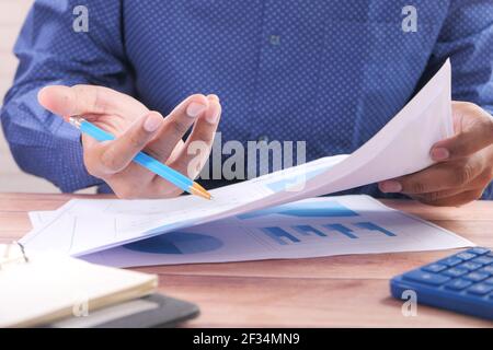 businessman analyzing bar chart on paper on office desk Stock Photo