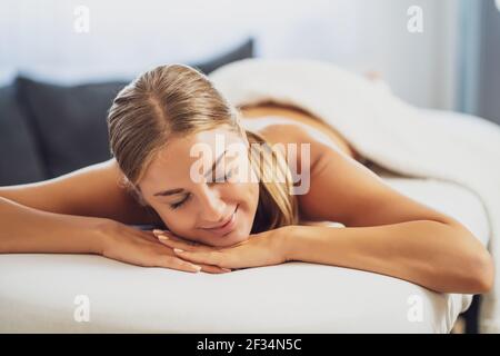Beautiful woman is relaxing massage at her home. Stress relief after work. Stock Photo