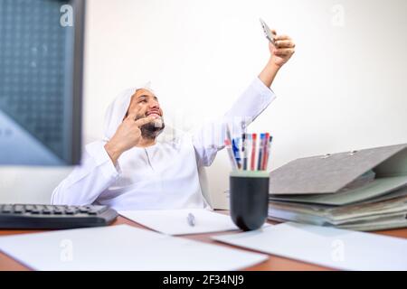 Arabic Muslim employee taking selfie at work Stock Photo - Alamy