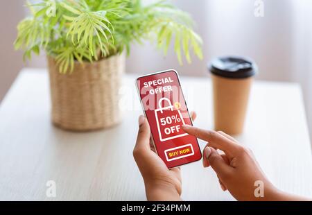 Black woman showing smartphone with shopping application screen Stock Photo