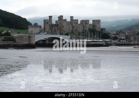 The brooding form of Conway Castle, North Wales looms out of the mist to guard the river crossing. Stock Photo