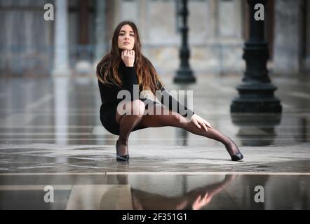 Legs covered from a pair of white stockings and white stiletto