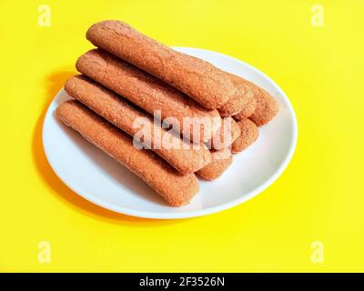 Sweet soft healthy soft spongy sprinkled sugar vanilla cookies (vainillas). Classic Argentine biscuits. Yellow background. High angle shot. Stock Photo