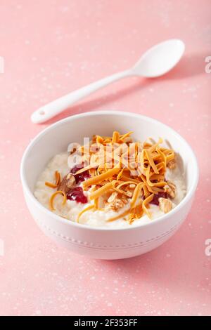 rice pudding with Norwegian brunost traditional brown cheese and raspberry jam Stock Photo