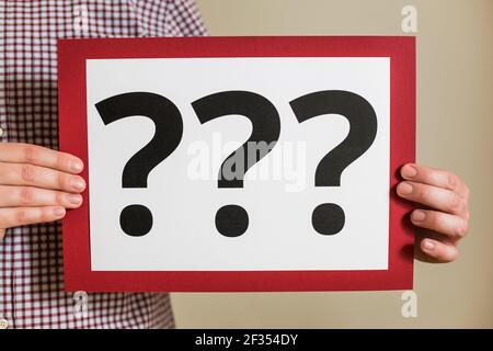 Man showing paper with question marks. Stock Photo