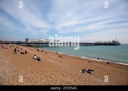 General view of people on the beach near to the closed Brighton Palace Pier Stock Photo