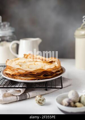 stack of thin crepes, pancakes. homemade breakfast. Shrove Tuesday, Maslenitsa holiday concept. vertical image. Gray background Stock Photo