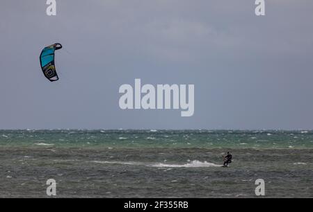 A windsurfer taking advantage of strong winds out on the water in Littlehampton, West Sussex Stock Photo