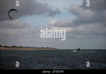 A windsurfer taking advantage of strong winds out on the water in Littlehampton, West Sussex Stock Photo