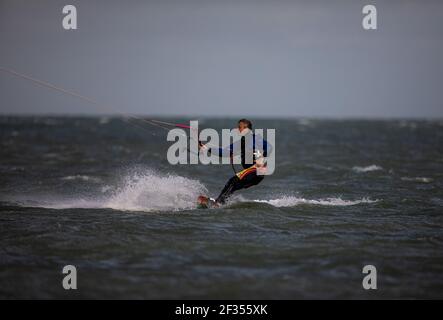 A windsurfer taking advantage of strong winds out on the water in Littlehampton, West Sussex Stock Photo